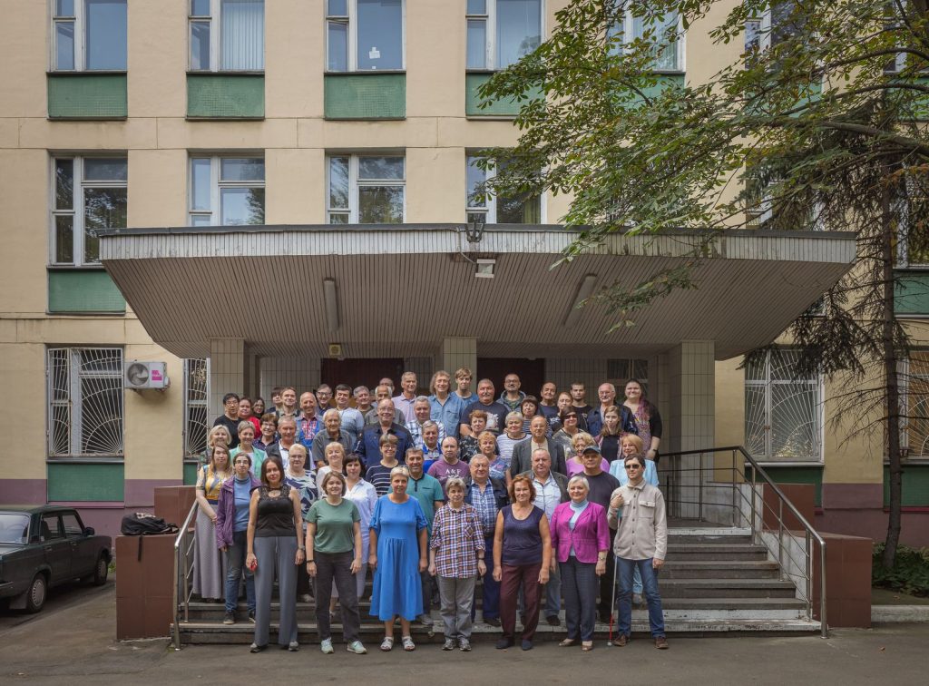 Фотография работников "Логосвос" на фоне здания предприятия.