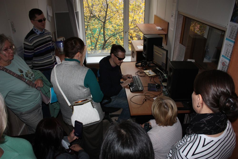 Гости в аппаратной цеха звукозаписи  общаются со звукорежиссером